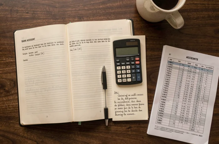Vue en plongée d'un bureau comptable avec manuel de comptabilité ouvert sur un plan comptable et calculatrice financière pour le compte 515