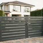 Portail coulissant anthracite avec portillon intégré devant une maison contemporaine et allée pavée
